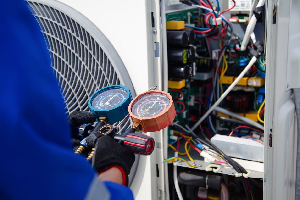 Cool Jay’s Air Conditioning technician inspecting a heating unit for safety and efficiency in Bakersfield